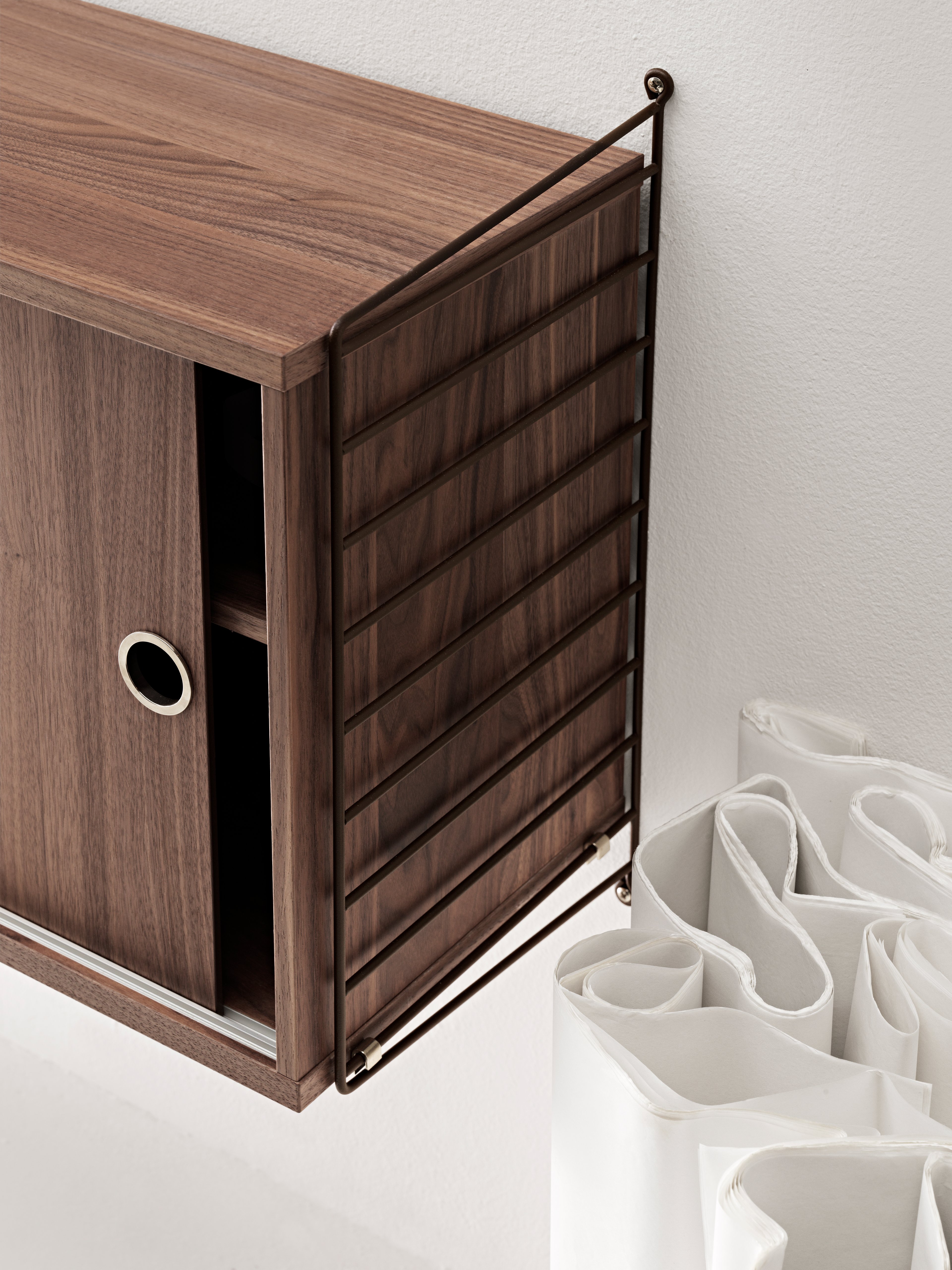 The cabinets with sliding doors are available in one width, 78 cm, along with two depths, 20 and 30 cm. The cabinets fit into all wire and plex panels from String® System. It is visually pleasing to add a bolder element to your shelf, like a cabinet, which also give you a lot of extra storage. The cabinet consists of one divider placed in the middle along with two adjustable inner shelves. The cabinet’s inner dimensions are 4 cm less than the outer dimensions. The cabinets are delivered unassembled.