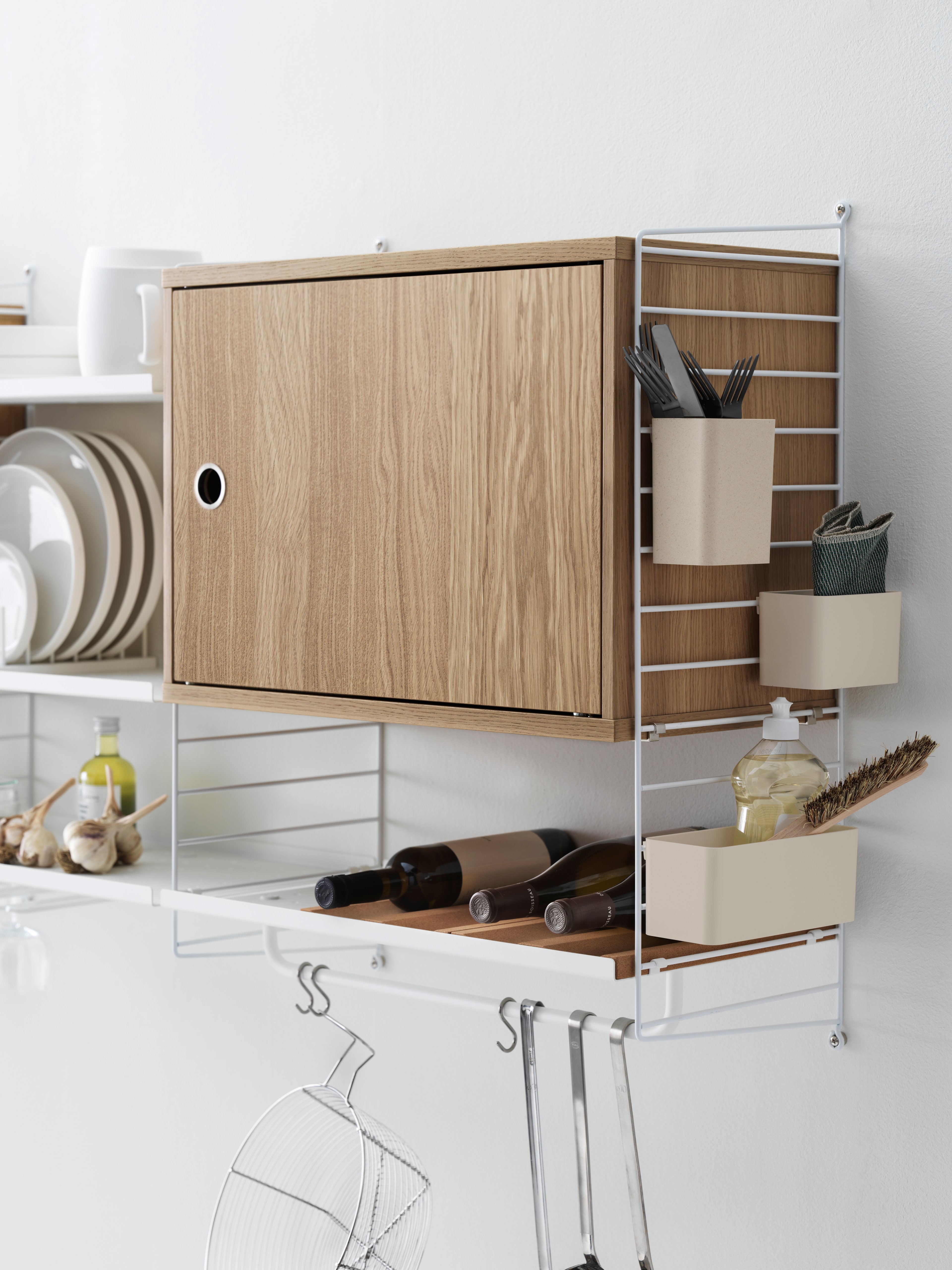 Das Schrankelement mit Schwenktür ist in der Breite 58 cm und der Tiefe 30 cm erhältlich. Das Schrankelement passt zu allen Regalleitern aus Metallgitter und Plexiglas von String® System mit einer Tiefe von 30 cm. Es sieht sehr stylisch aus, wenn Sie mit einem auffälligeren Element, beispielsweise einem Schrankelement, Akzente in Ihrem Regalsystem setzen. Außerdem gewinnen Sie dadurch mehr Stauraum. Die Tür kann an jeder Seite des Schrankelements angebracht werden. Das Schrankelement besteht aus einem Einlegeboden, der versetzt werden kann. Die Innenmaße betragen: T 54 x T 26 x H 38 cm. Das Schrankelement wird zerlegt geliefert.