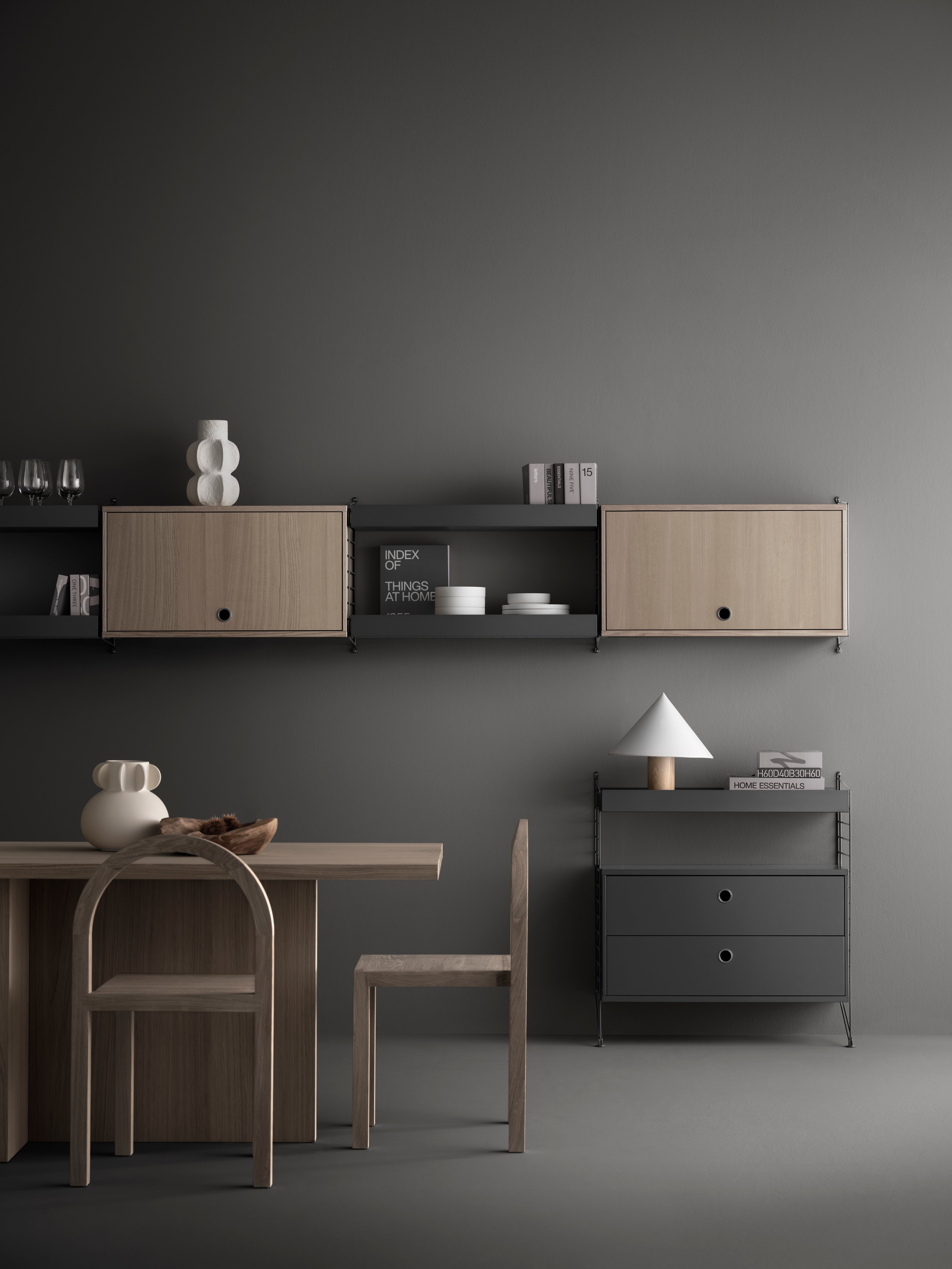The Cabinet with flip door is available in two widths, 78 cm and 58cm, and one depth, 30 cm. The height of the cabinet is 42 cm. The cabinet fits together with all 30 cm deep wire and plex panels from String® System. The cabinet consists of one adjustable inner shelf. The internal dimensions are w75/w54 x d28.5 x h38 cm. The cabinet is delivered unassembled.